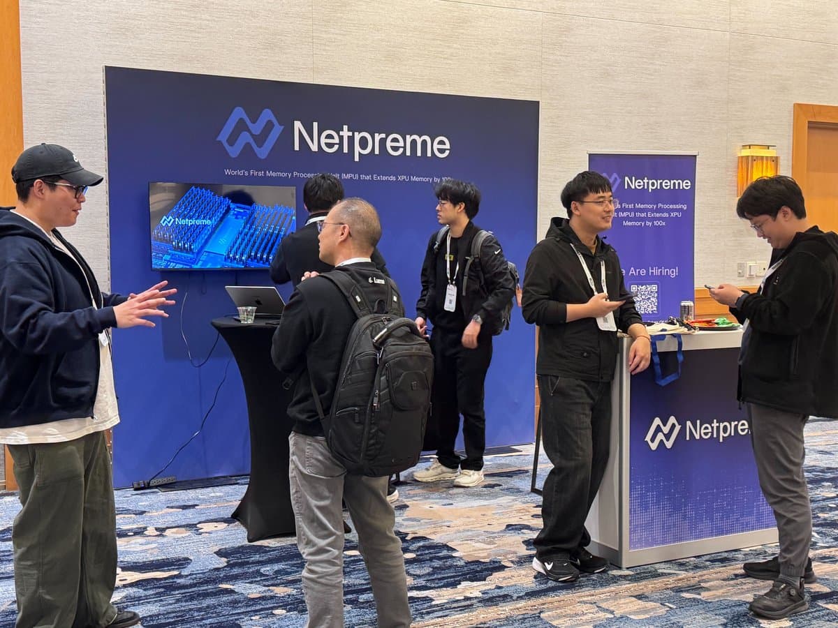 Attendees talking with Netpreme engineers at the MLSys 2026 booth, beside a We Are Hiring banner